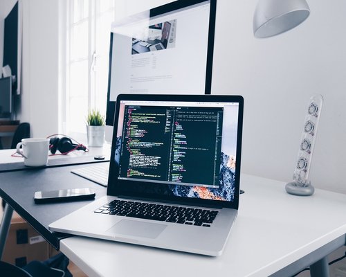 Person adjusting monitor distance in a home office setup in Mexico
